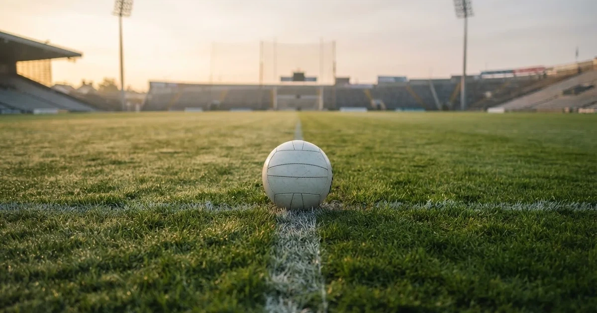 A ball on the centre spot of a grass pitch in morning light