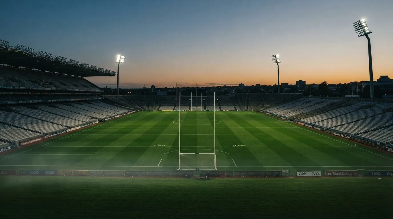 An empty football stadium with floodlight masts at dusk