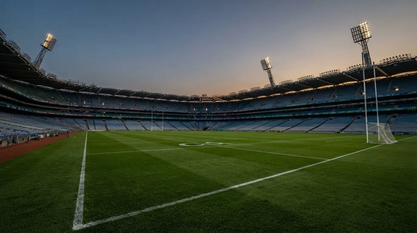 An empty football stadium with floodlight masts at dusk
