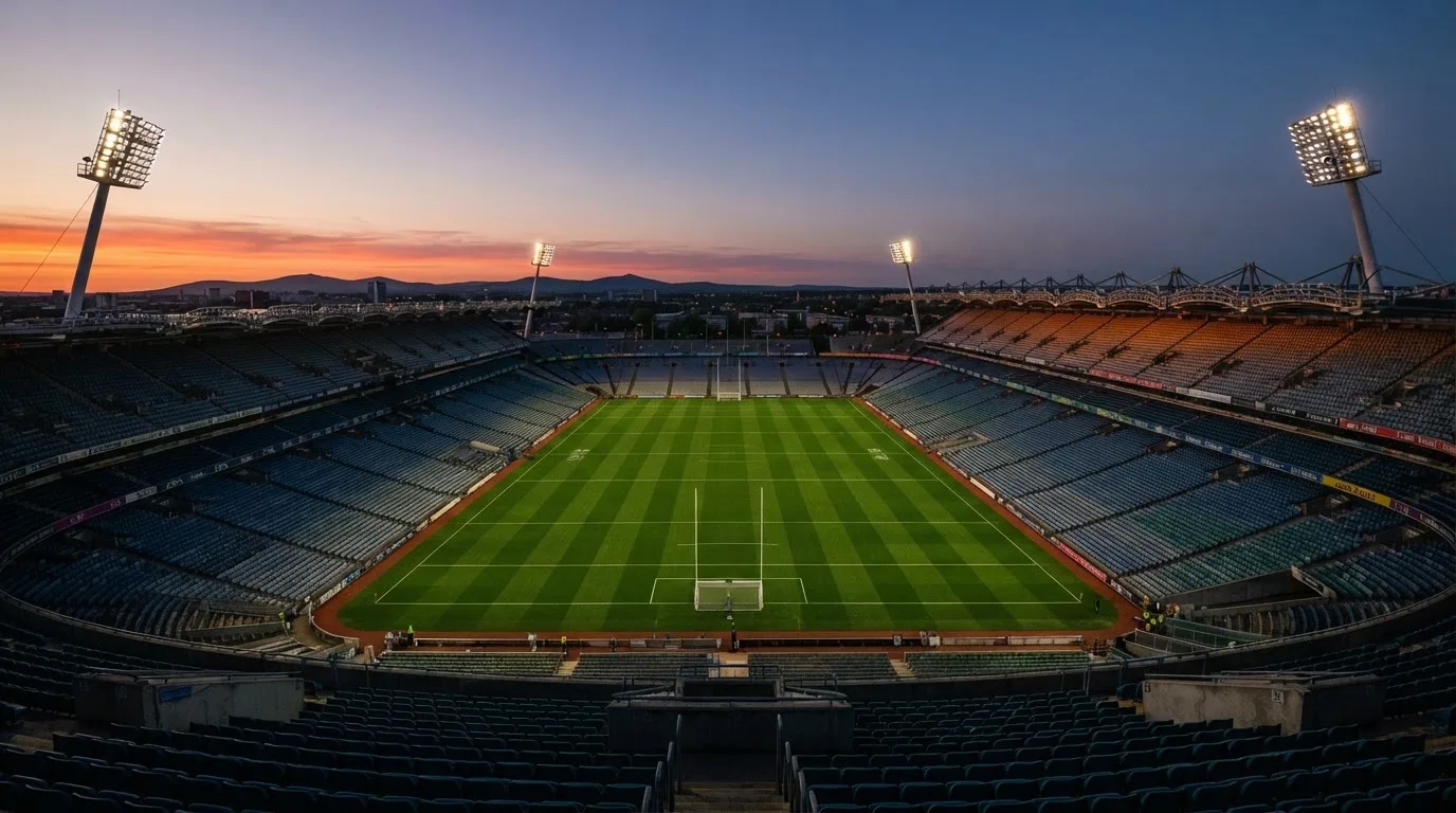 An empty football stadium with floodlight masts at dusk